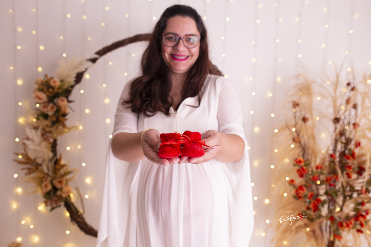 a gestante mostra os sapatinhos no ensaio