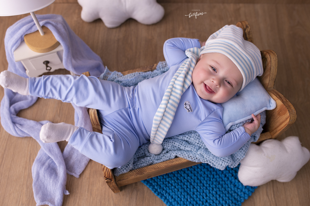 o menino esta deitado para as fotos do acompanhamento mensal