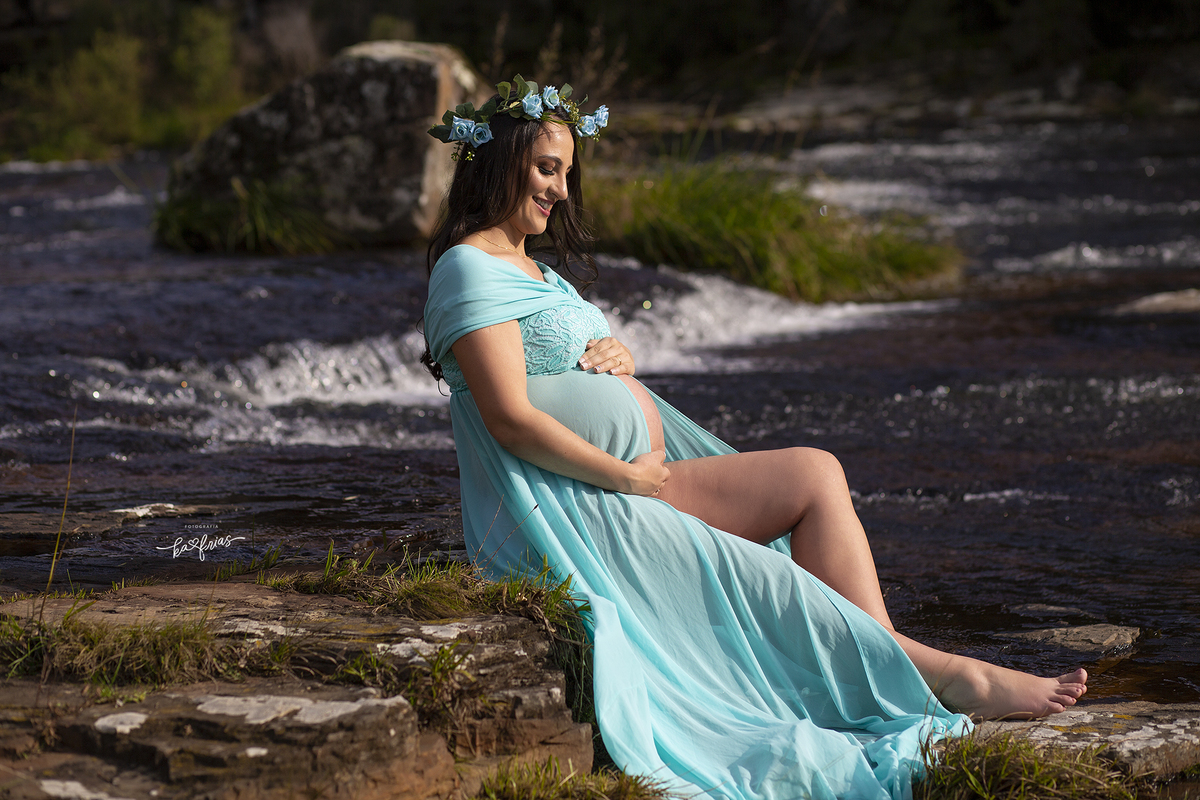 a gestante olha para a barriga no ensaio externo