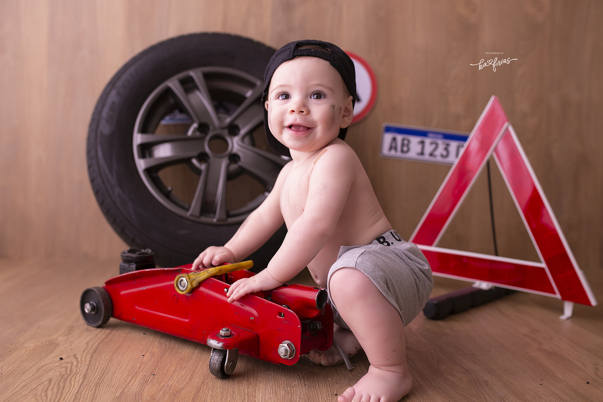 no acompanhamento mensal o bebe esta vestido de mecanico