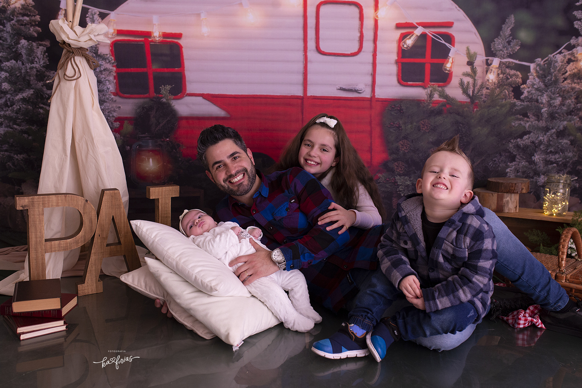 o pai brinca com os filhos na sessão de fotos