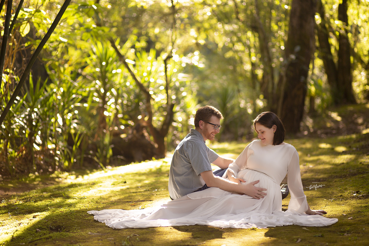 os pais olham par a barriga no book de gestante