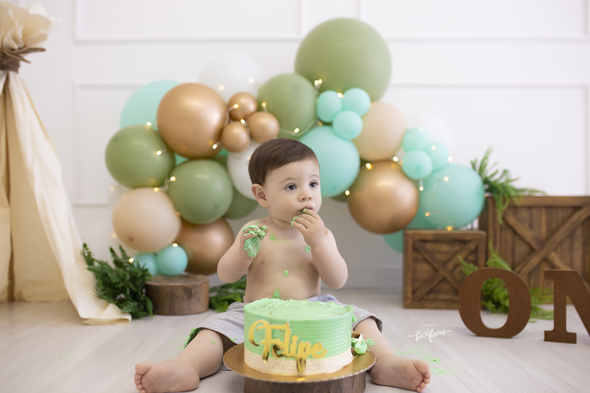o menino come o bolo no ensaio infantil