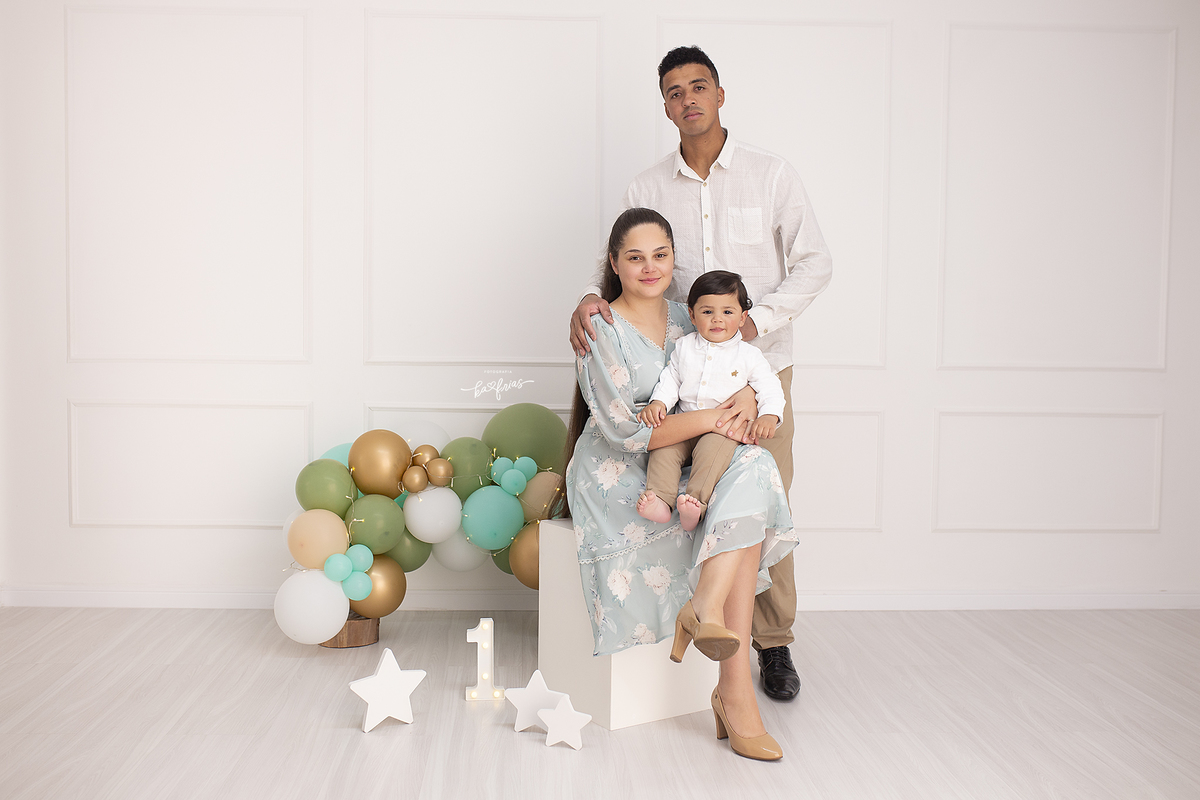 a familia posa para as fotos de um aninho