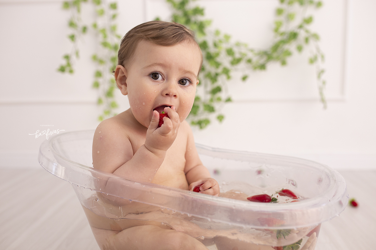 o menino come o morango na sessão de fotos