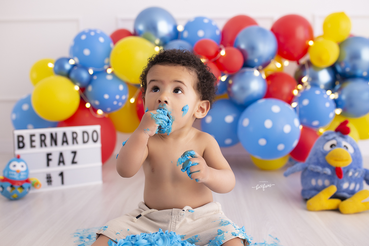 o menino come o bolo na sessão de fotos