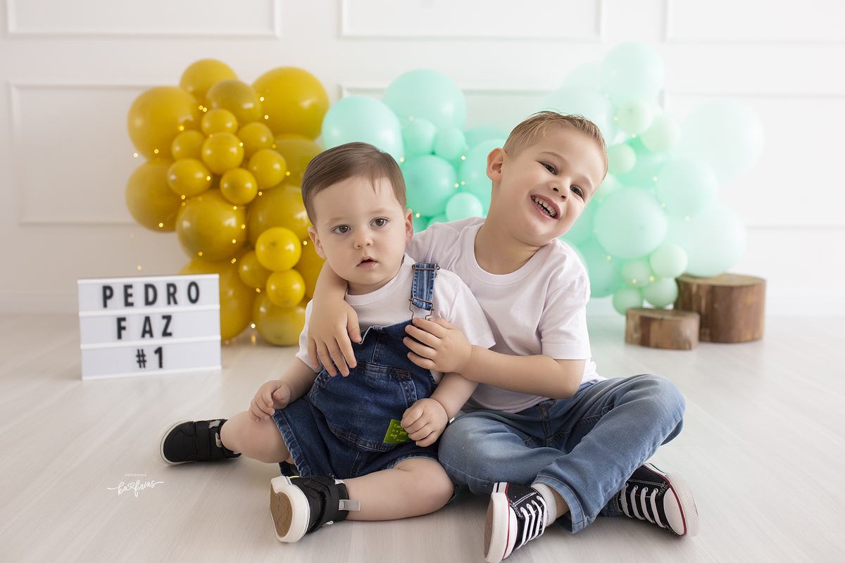 os irmaos se abraçam no ensaio de um aninho