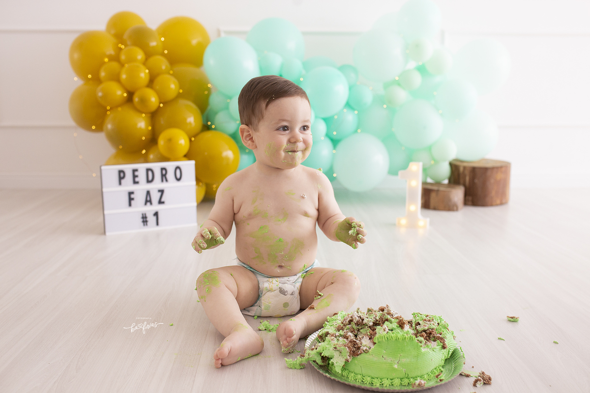 o menino se suja com o bolo na sessão smash