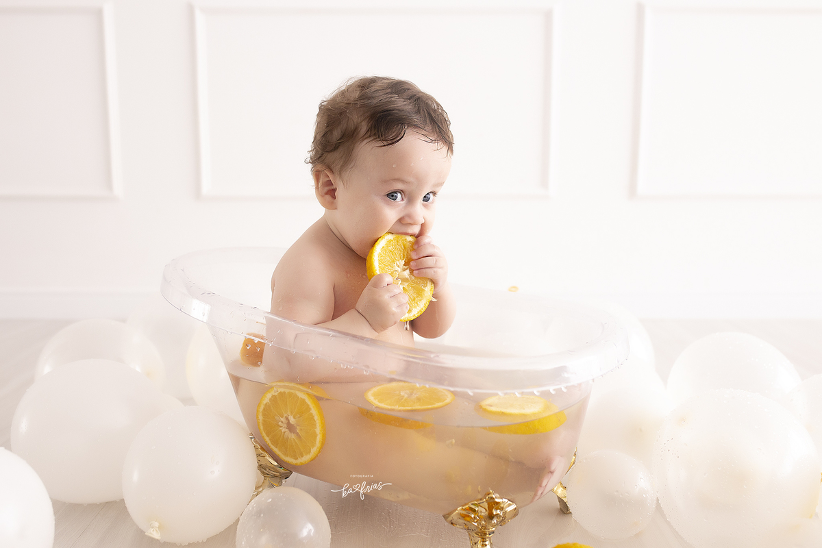o bebe come a laranja na sessão de fotos