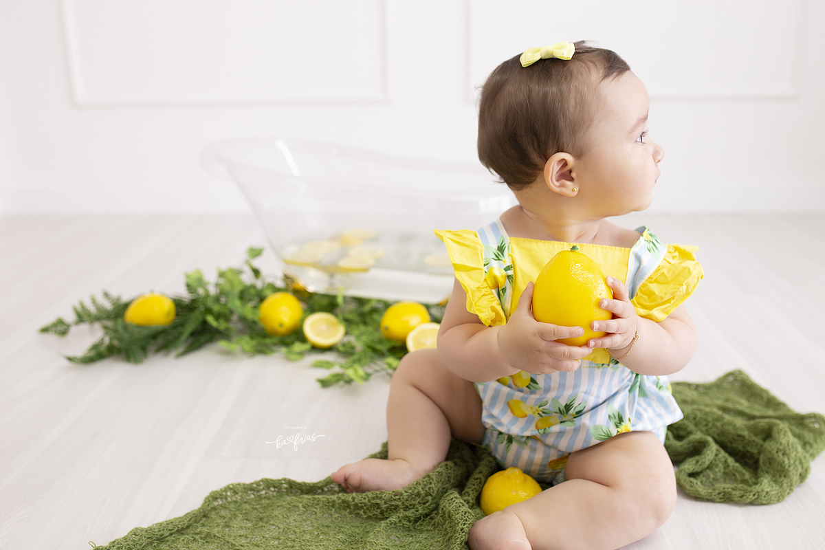 no ensaio infantil a bebe olha para a o lado