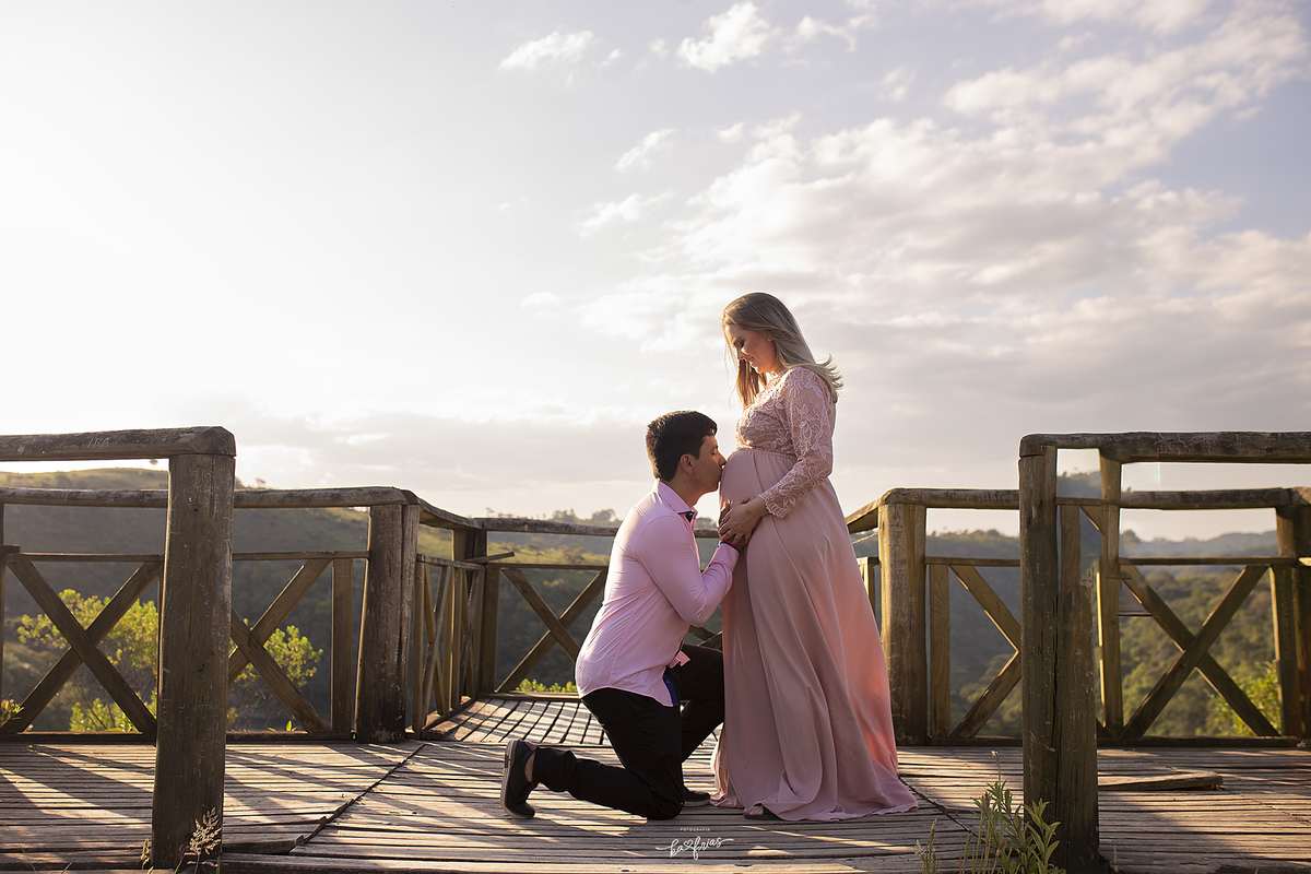 o pai beija a barriga da gestante no ensaio externo