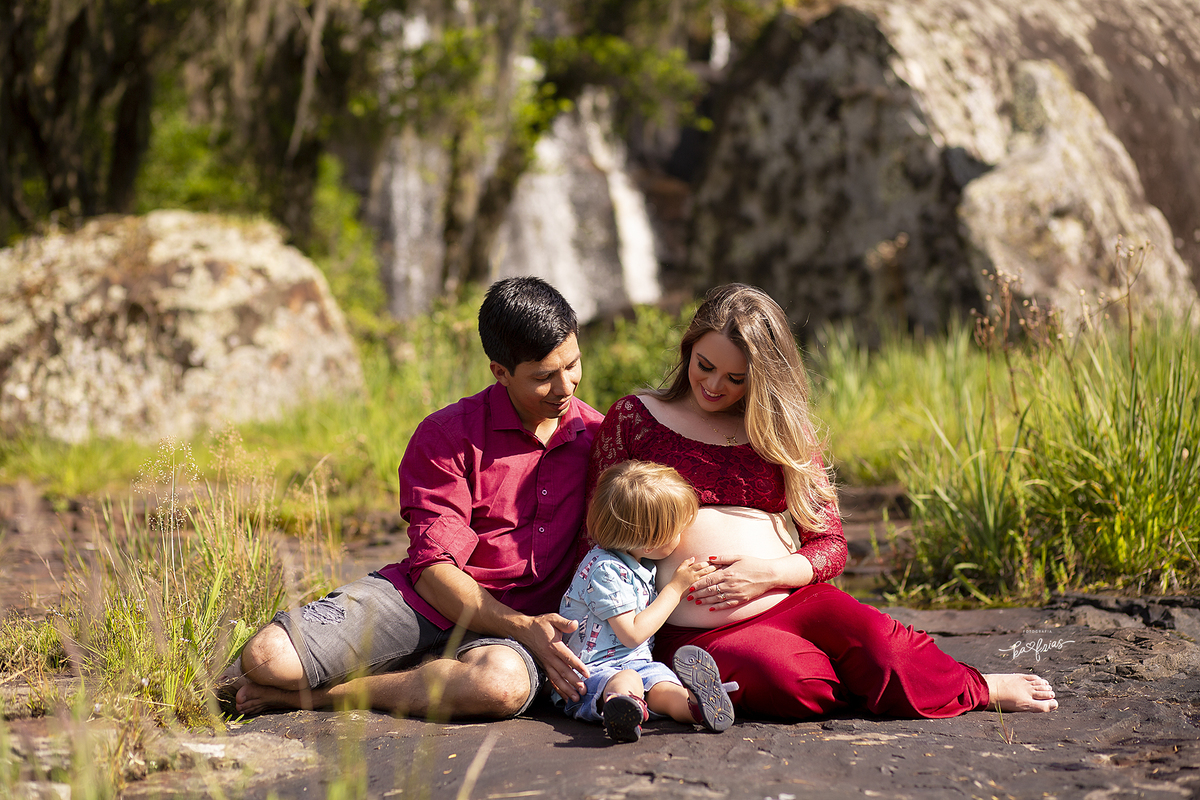 o filho mais novo beija a barriga da mãe