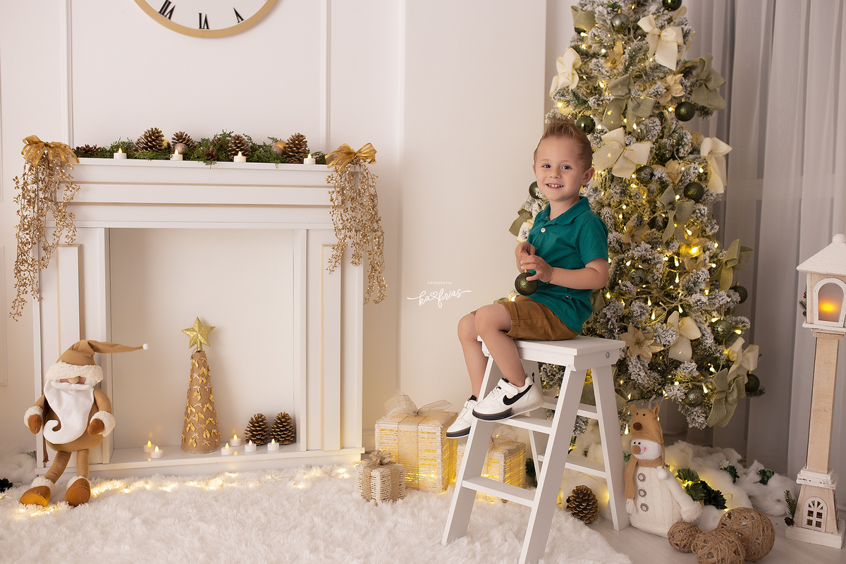 o menino sobe na escada para arrumar a arvore de natal