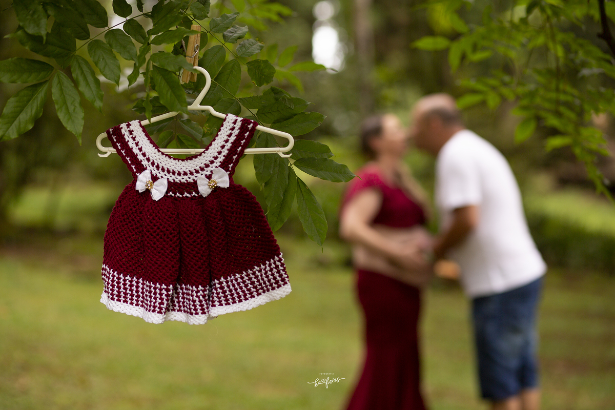 os pais estão ao fundo na fotografia de gestante