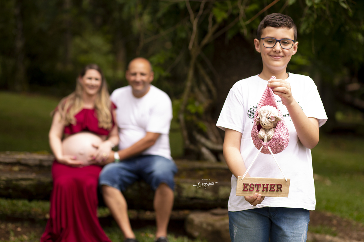 o irmao mais velho segura a plaquinha da bebe