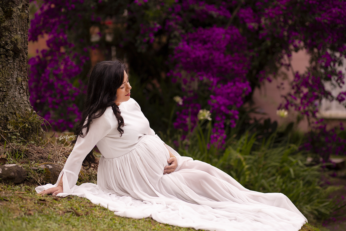 a gestante esta sentada para as fotos externas