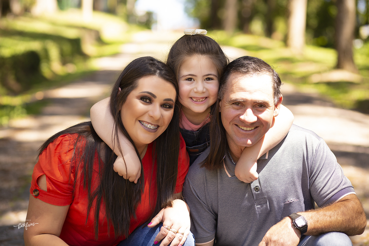 a menina abraça os pais nas fotos de familia