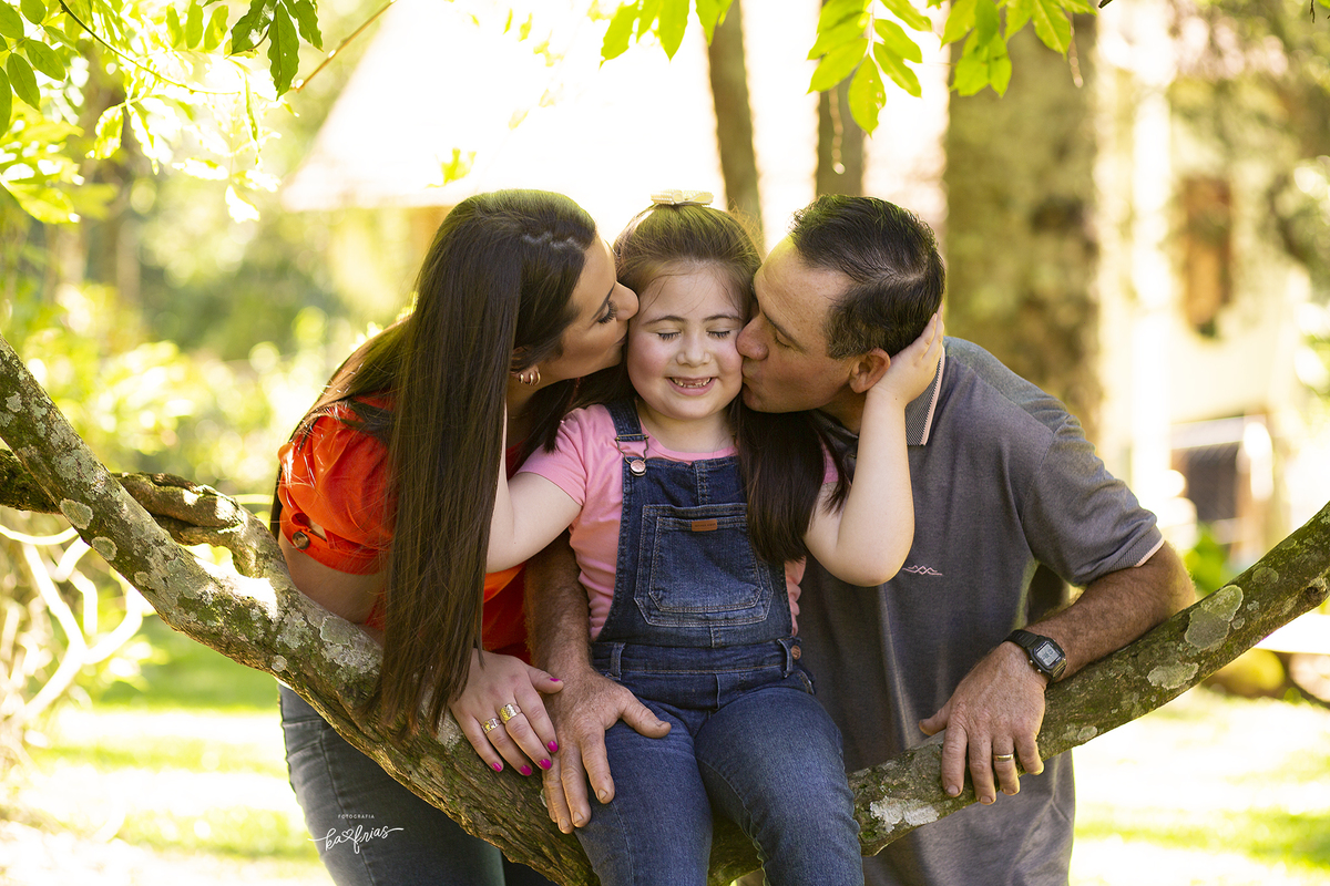 os pais beijam a filha nas fotos de familia