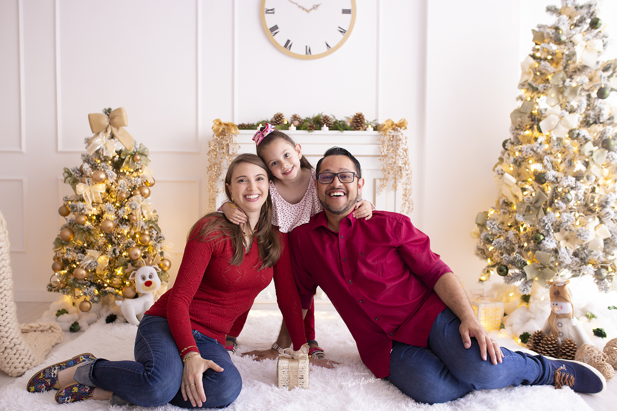 a filha abraça os pais no ensaio de natal