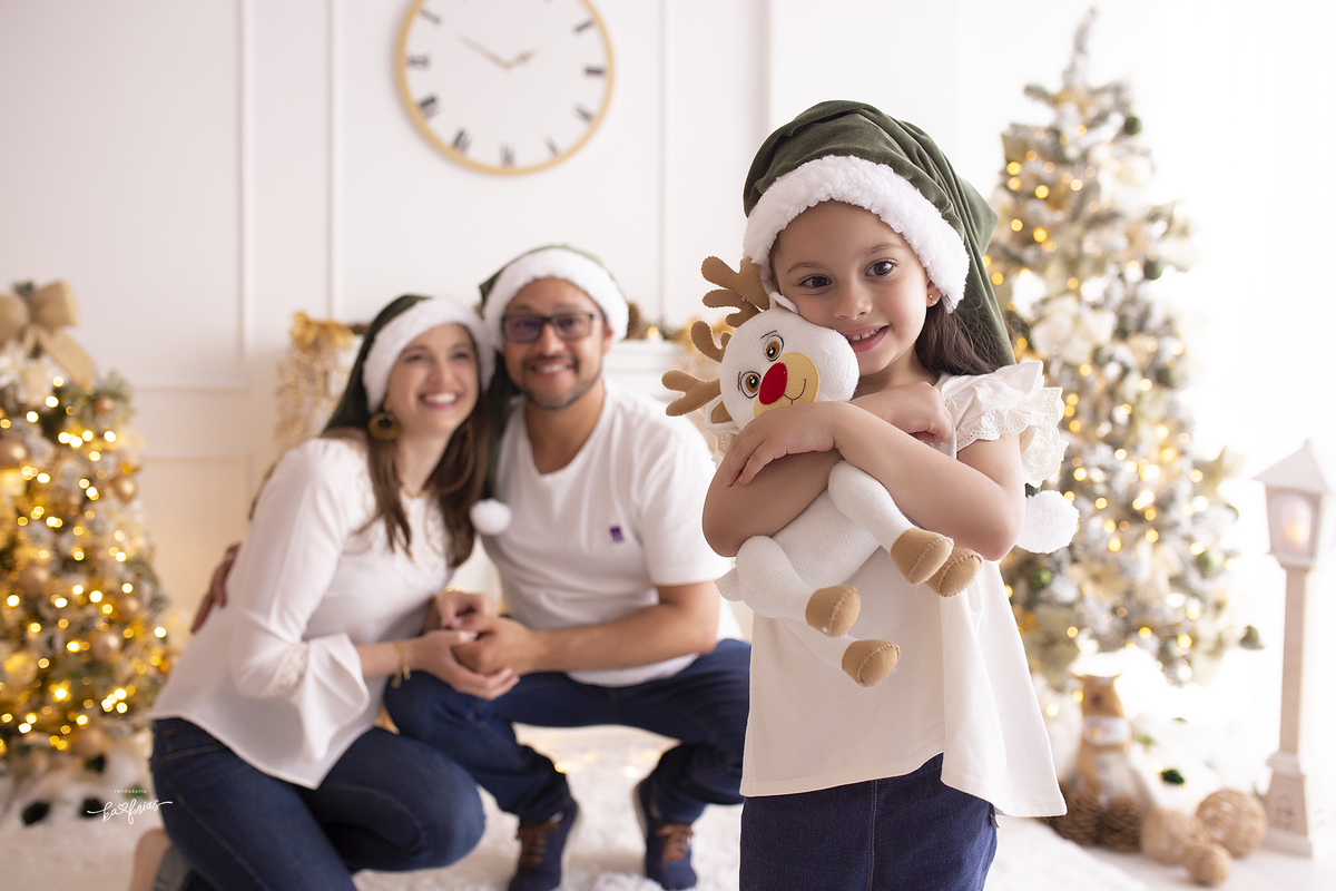 os pais estao desfocados ao fundo no ensaio de natal