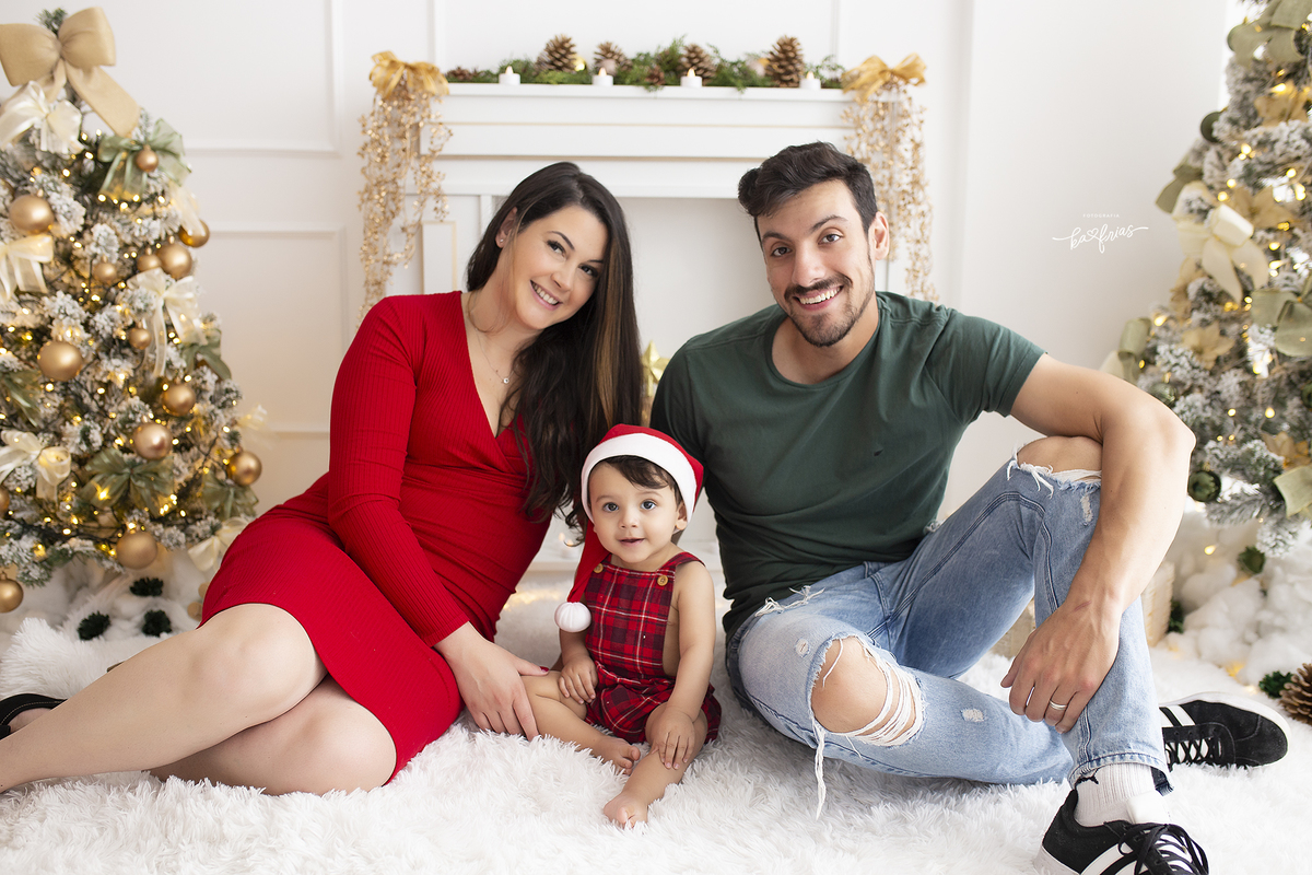 os pais posam com o bebe para a foto