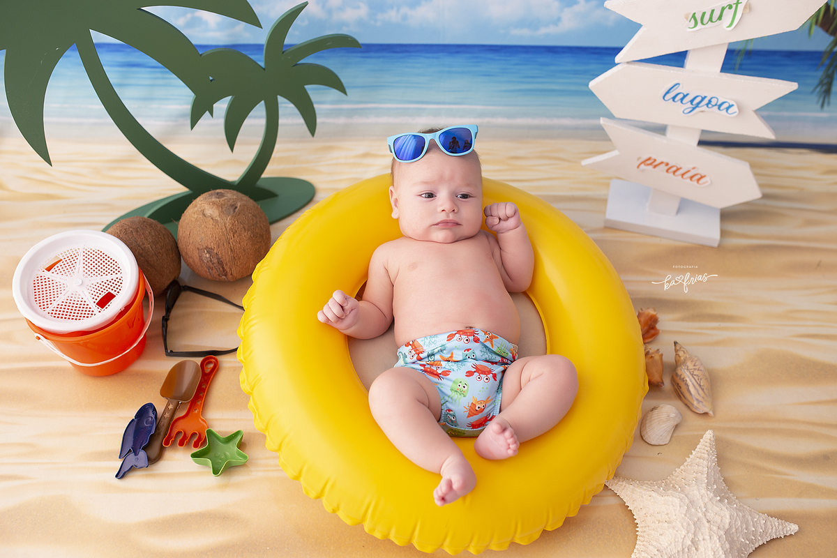 o bebe esta deitado na boia nas fotos de acompanhamento mensal