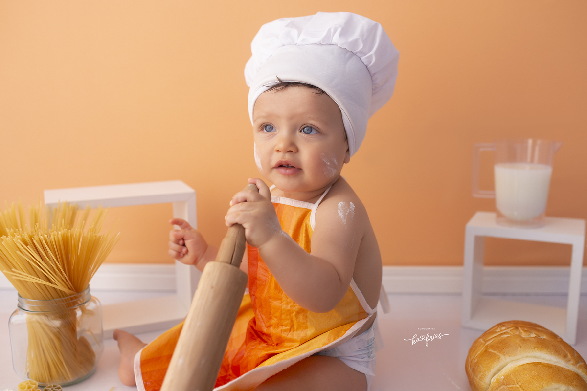 o bebe esta vestido de padeiro para as fotos mensais