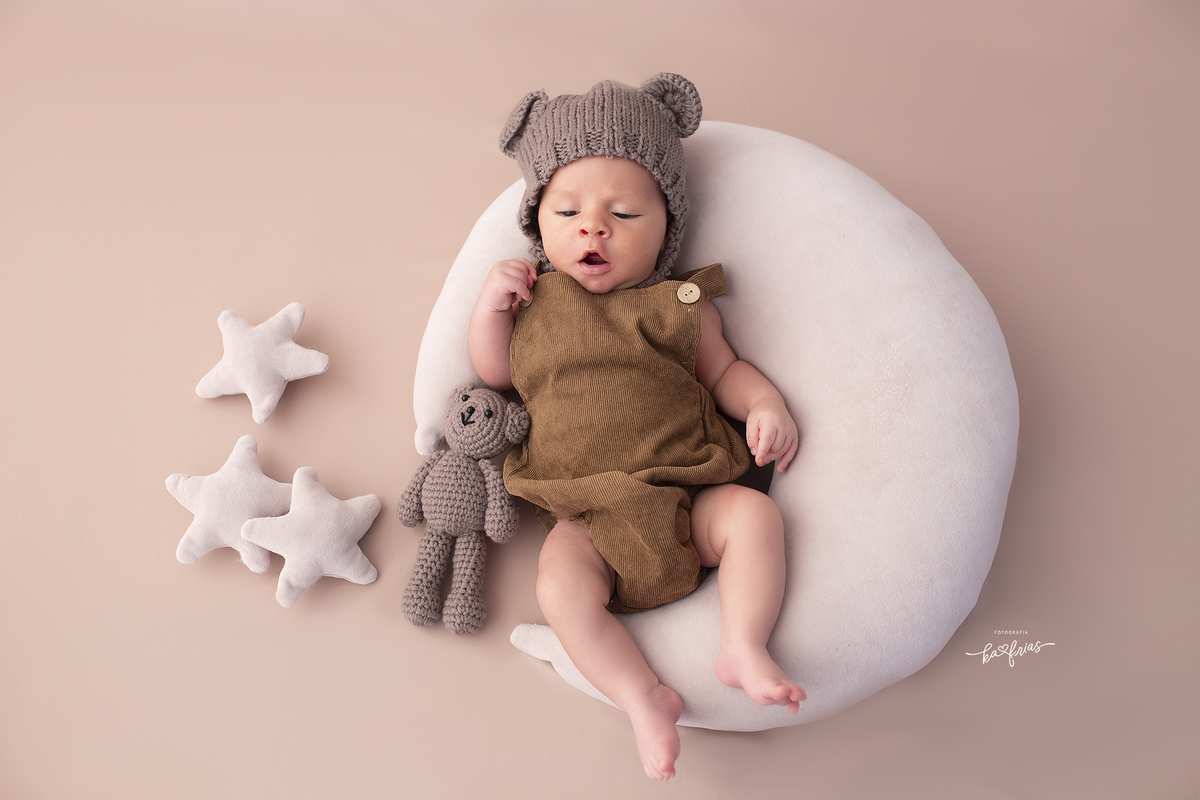 o bebe esta deitado na lua para as foto do acompanhamento mensal