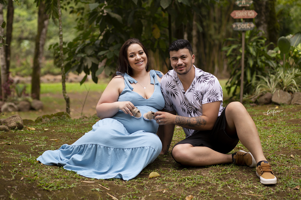 os pais seguram o sapatinho no ensaio gestante