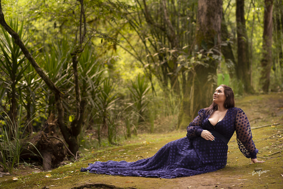 a gestante esta sentada para a sessão de fotos