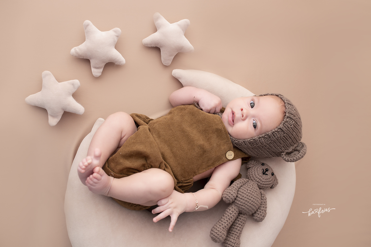 o bebe esta vestido de urso para as fotos mensais