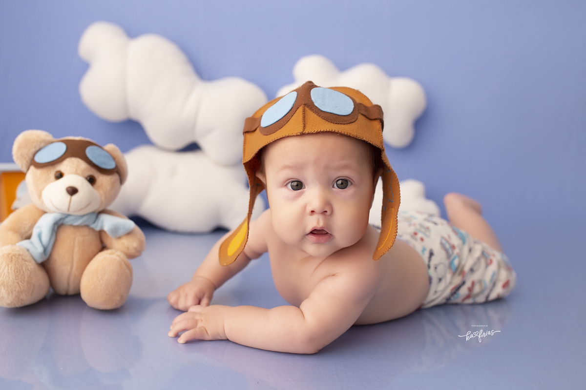 o bebe esta vestido de aviador para as fotos mensais