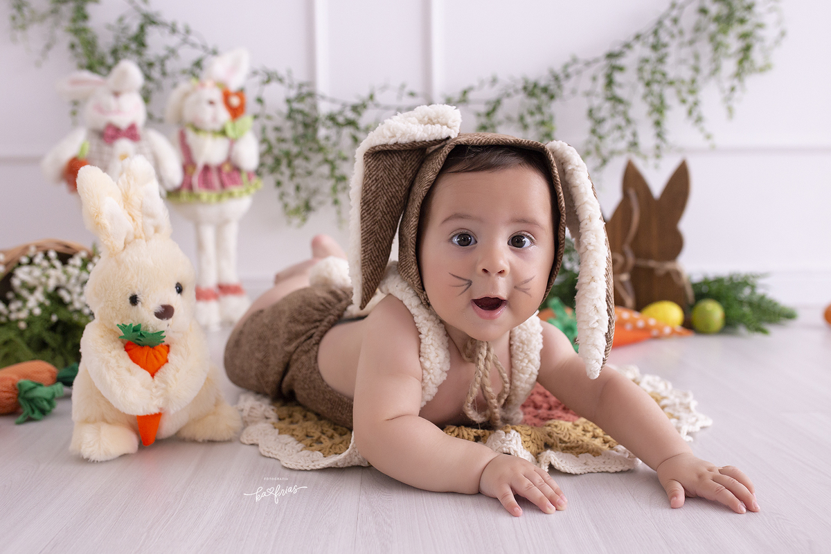 o menino esta vestido de coelho para as fotos mensais