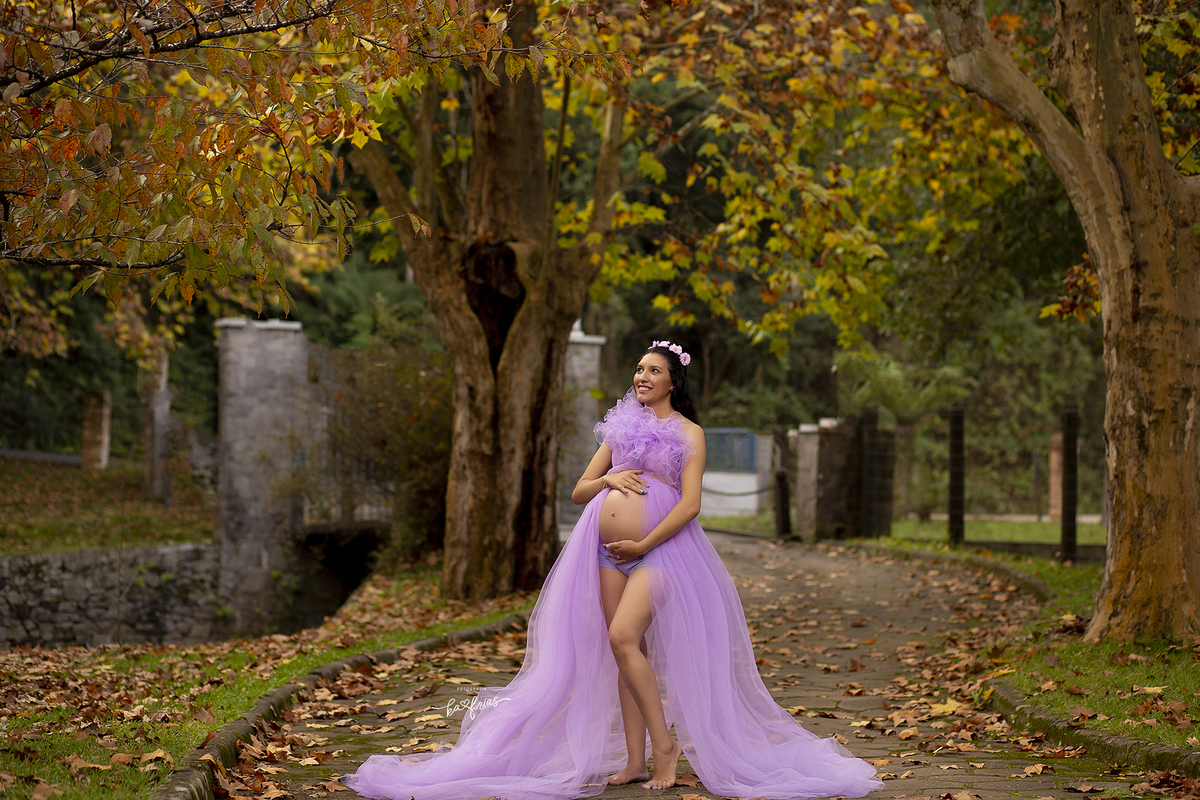 a modelo sorri nas fotos de gestante externas