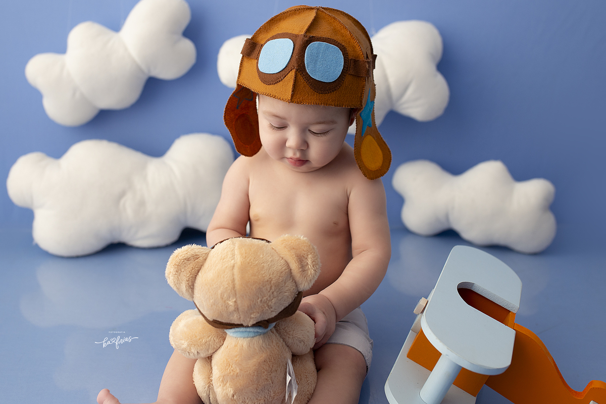 o bebe olha para o urso no ensaio infantil