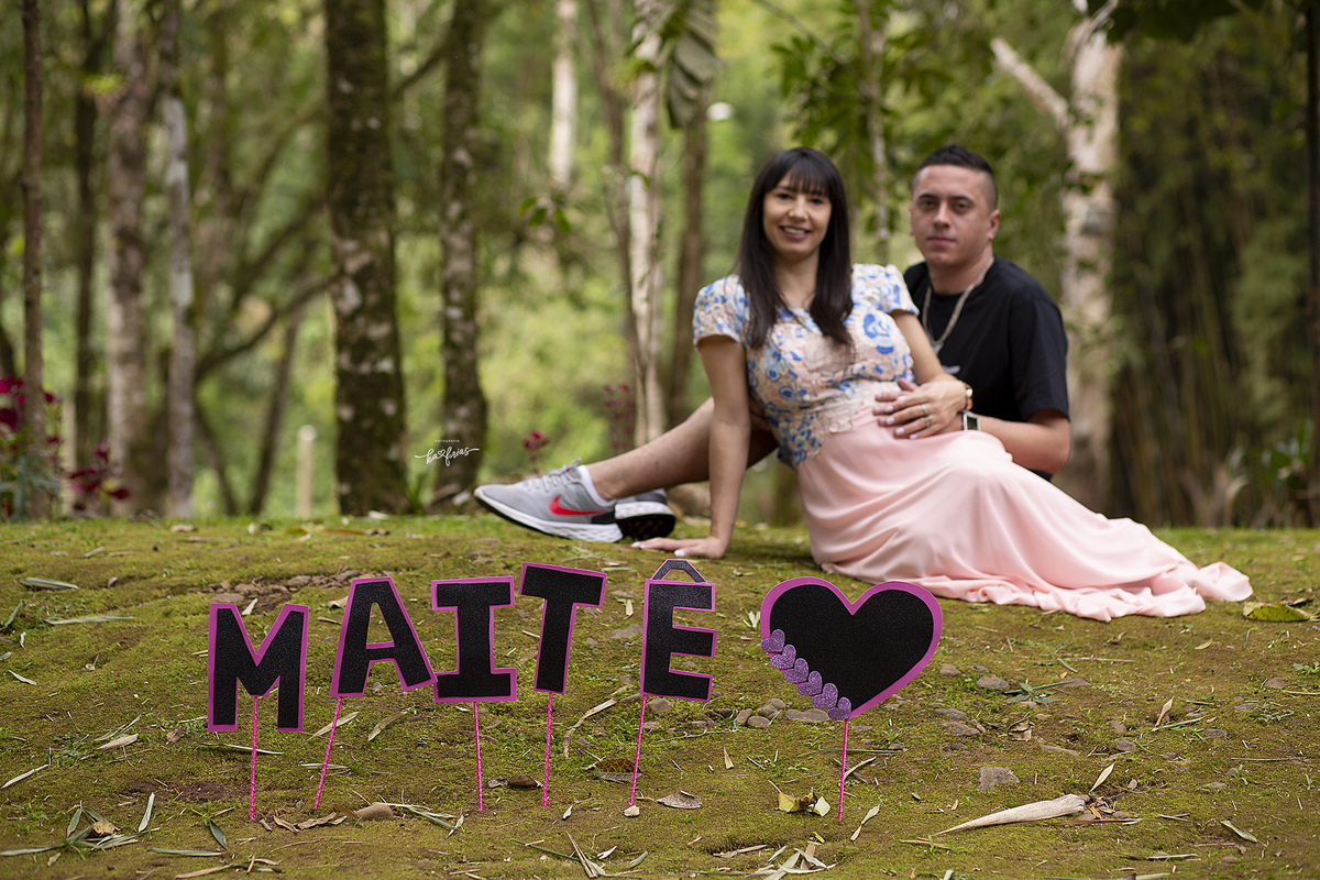 os pais estao ao fundo no ensaio de gestante