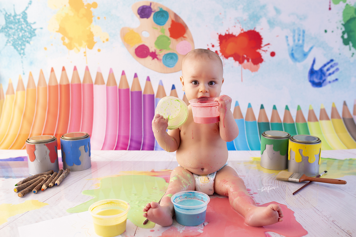 o menino brinca com as tintas no ensaio de acompanhamento mensal