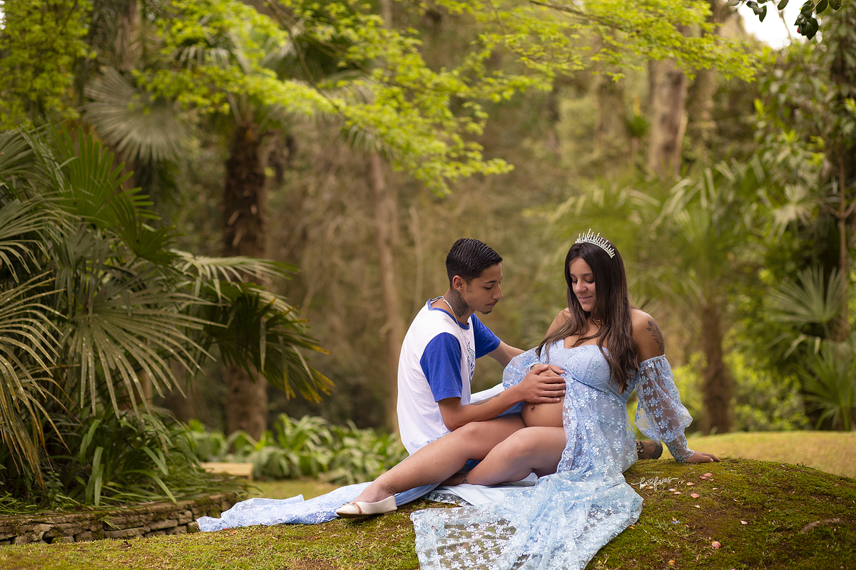 no ensaio de gestante externo, os pais olham para a barriga