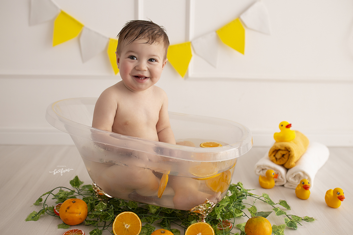 o menino brinca na agua no ensaio infantil