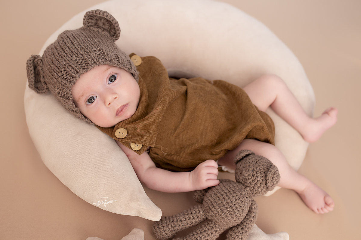 no ensaio infantil o bebe segura o urso