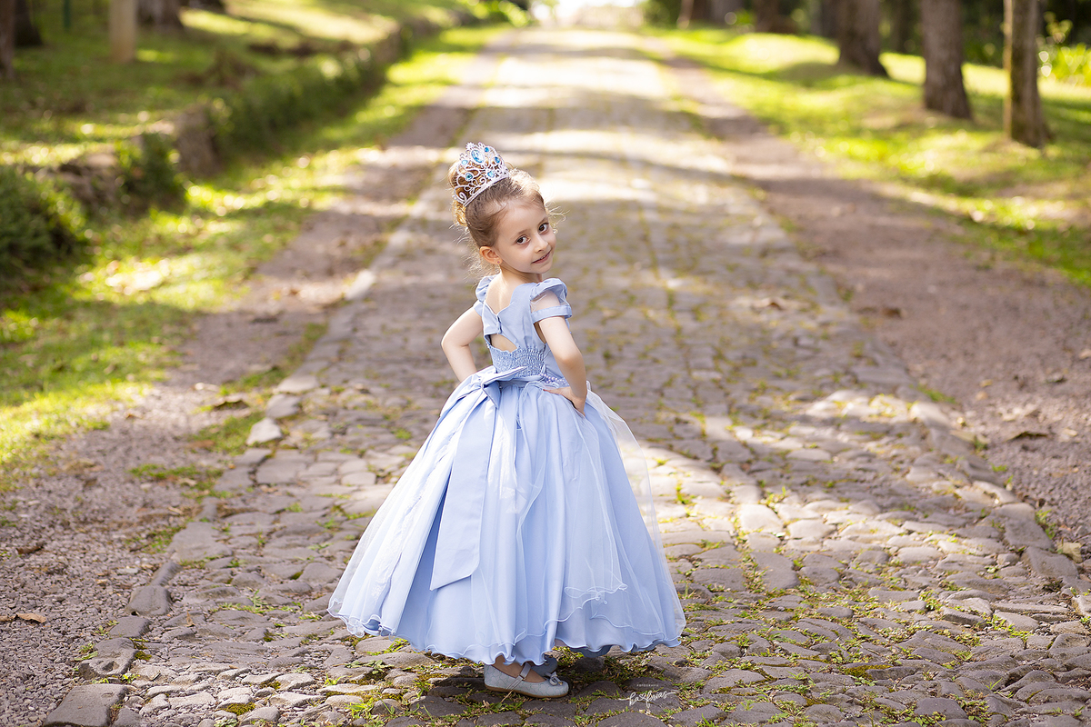a menina esta vestida de princesa para suas fotos de 05 anos