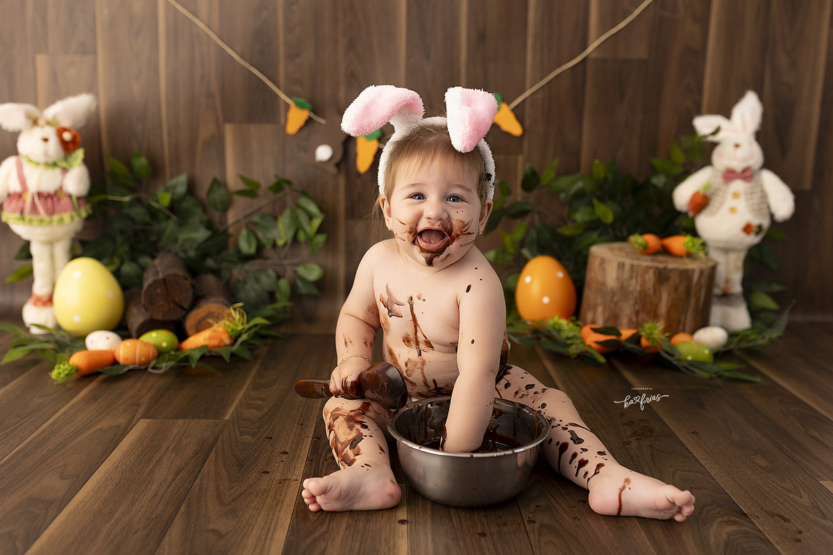 a bebe brinca com chocolate na sessão de fotos