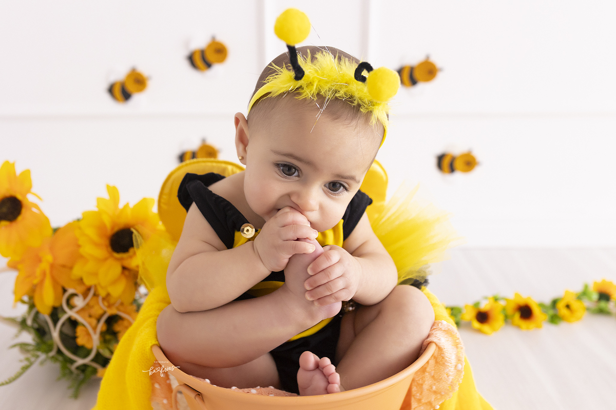 a bebe poe o pé na boca na sessão de fotos