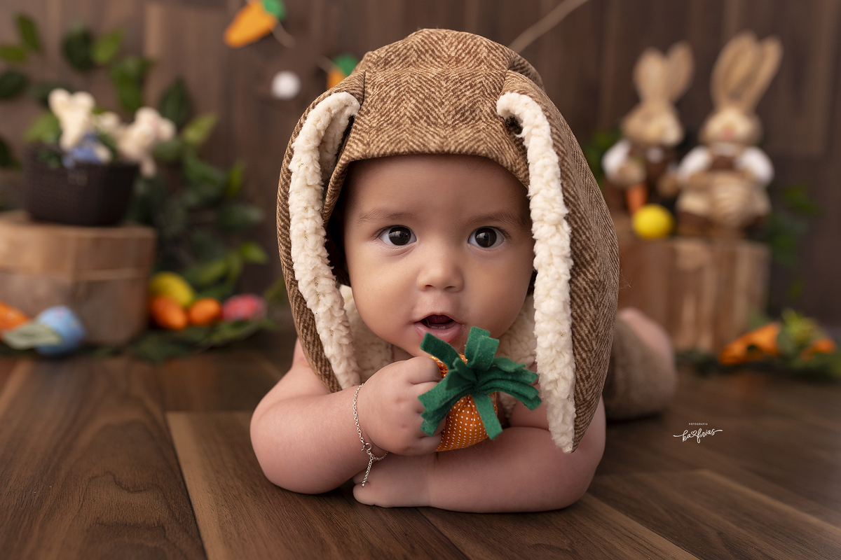 o menino esta deitado para as fotos de pascoa em caxias do sul