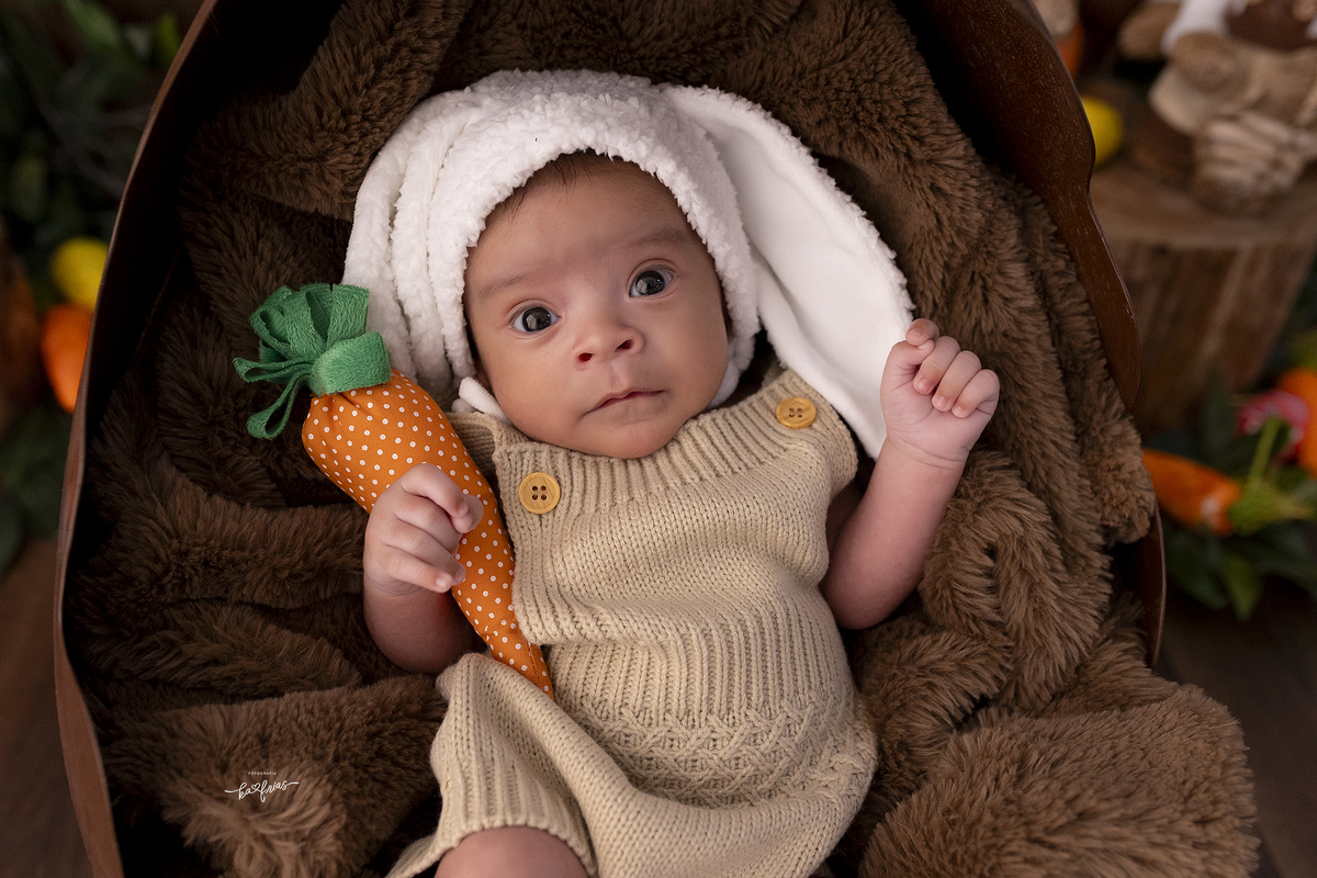 o menino olha para a fotografa infantil no ensaio de pascoa 2025
