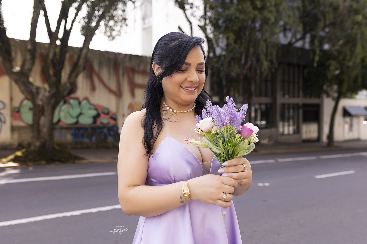 a noiva olha o buque nas fotos de casamento