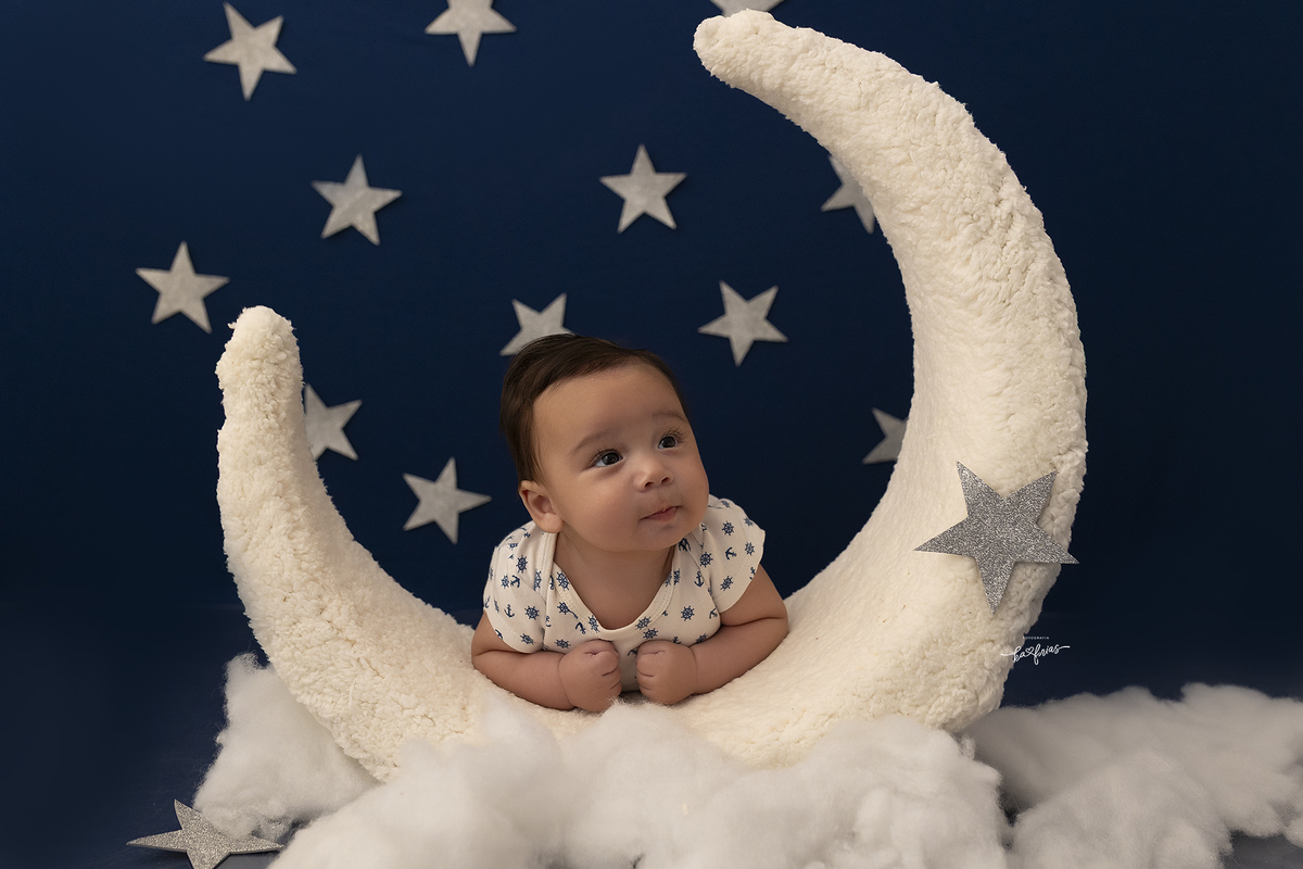 o menino esta olhando a lua na sessão de fotos