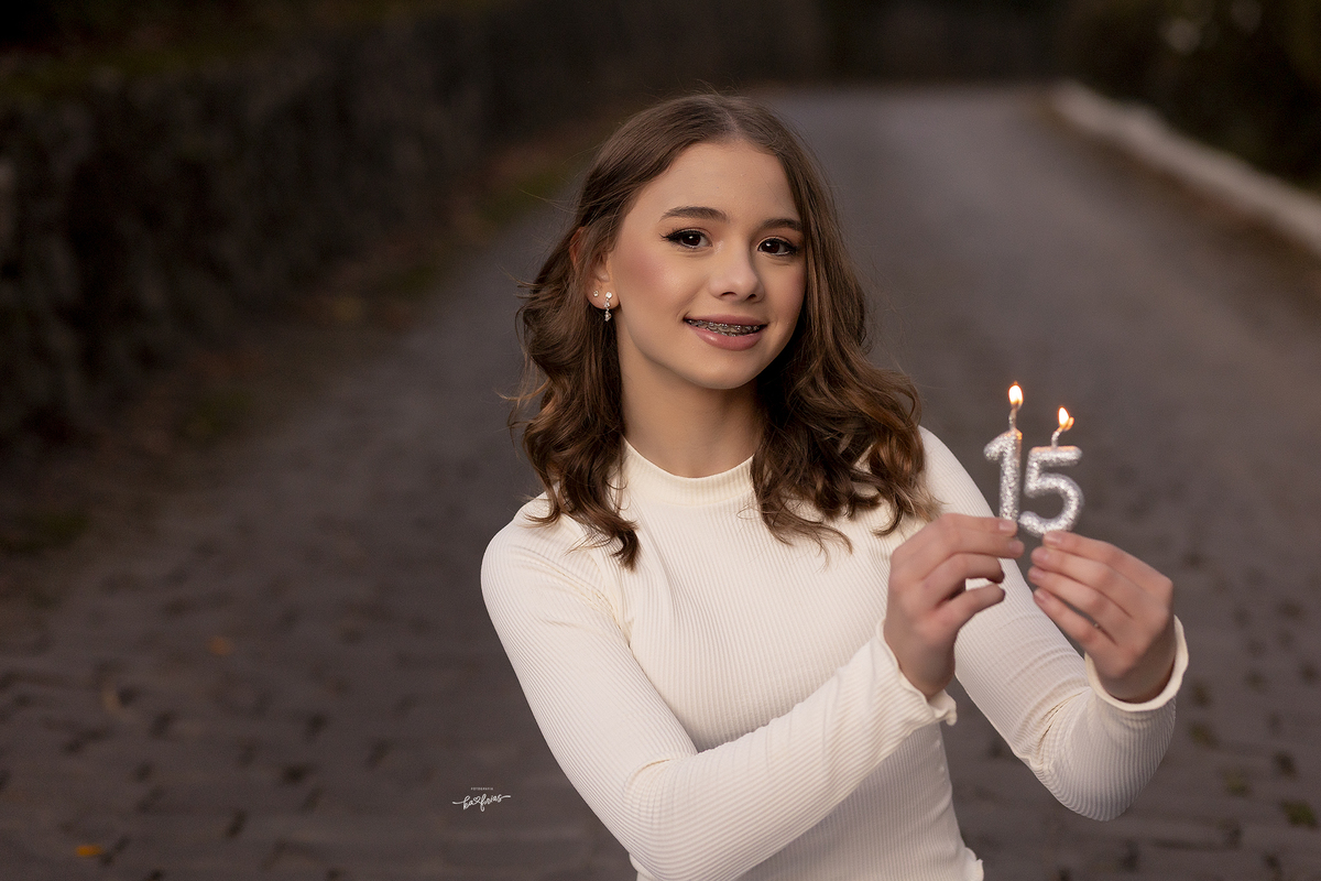a menina segura as velas para as fotos de 15 anos