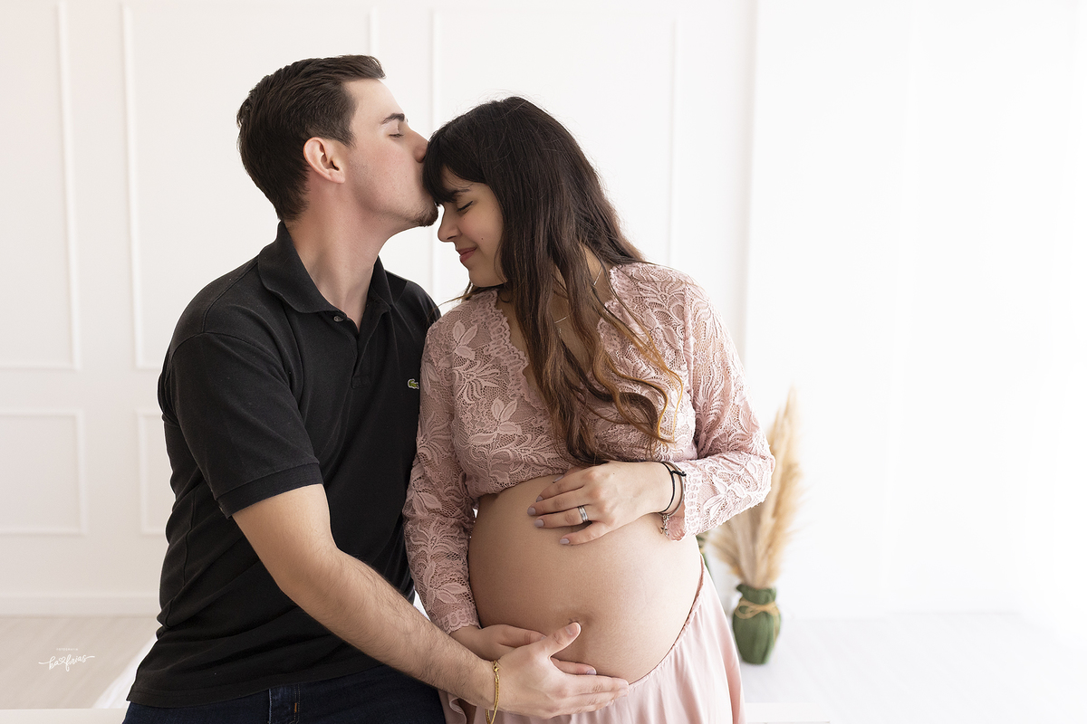 o pai beija a testa da gestante no ensaio em estudio