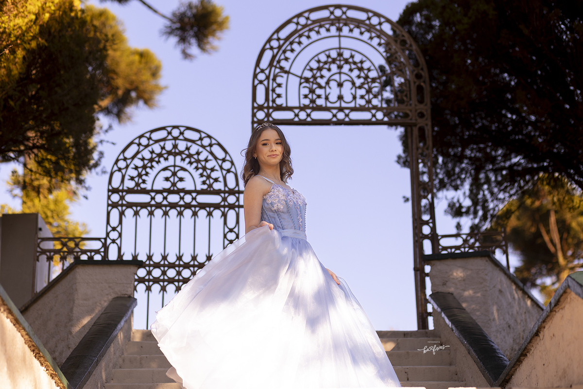 a menina esta com o vestido de 15 anos para as fotos